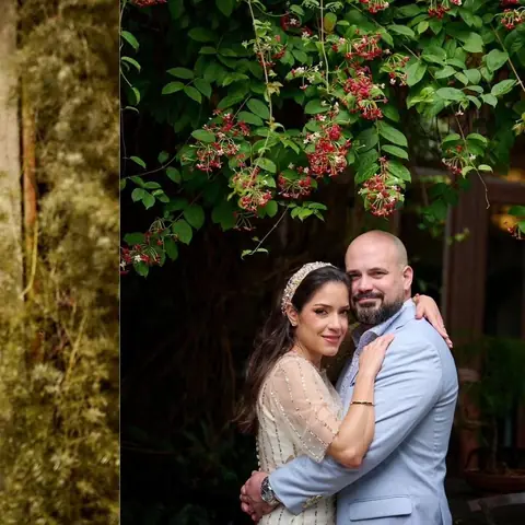 Pareja de novios abrazada entre plantas, con luz natural