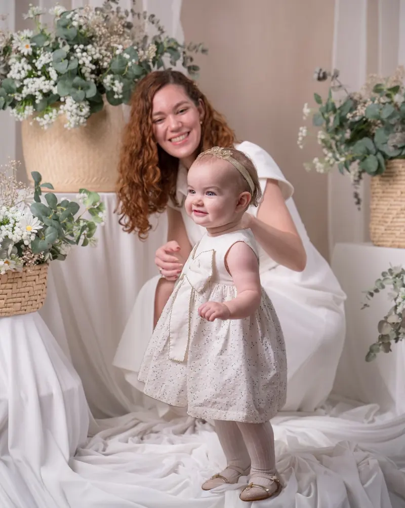Mamá y bebé con vestidos blancos en el estudio