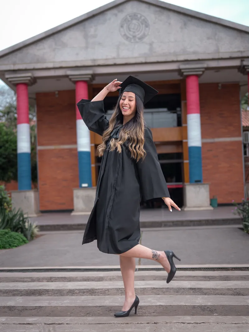 Graduada con toga y birrete saludando a la cámara