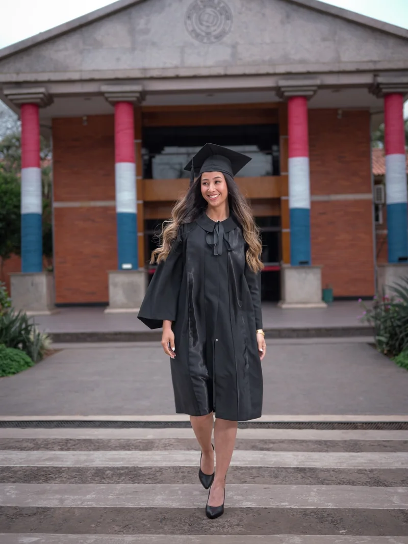 Graduada caminando con la toga frente al edificio